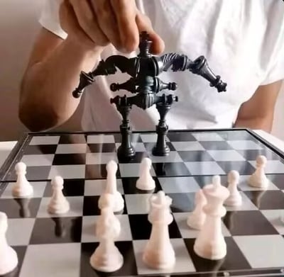 图片中，一只手正将一枚造型怪异的黑色国际象棋棋子（形似多个棋子融合的多肢结构）放置在棋盘上。棋盘上已整齐排列着多个白色兵（pawns），而这枚黑色棋子的复杂形态与常规棋子形成强烈反差，显得极不公平。配合标题“我去，这怎么赢？！”，生动表达了面对这种“开挂”式棋子时的无奈与震惊，充满搞笑吐槽意味。