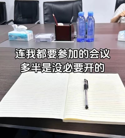 办公室会议室场景，桌子上摆放着笔记本、笔、矿泉水瓶和纸巾盒，前景是一本打开的空白笔记本。图片中央有文字：'连我都要参加的会议 多半是没必要开的'，表达了对职场中不必要会议的吐槽和无奈。