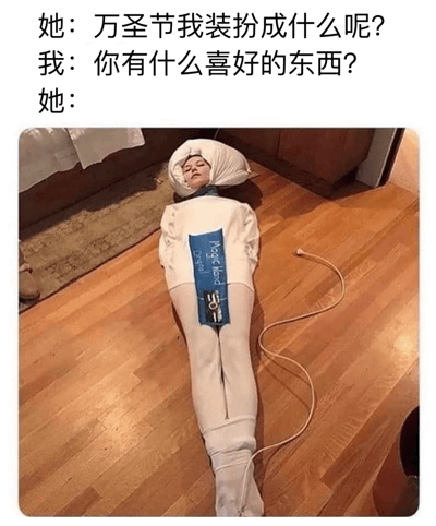 一张万圣节主题的搞笑梗图，上方是对话文字：“她：万圣节我装扮成什么呢？我：你有什么喜好的东西？她：”，下方配图是一个人躺在木地板上，全身被白色类似加热垫的物品包裹，头部枕着白色物体，身上有蓝色标签写着“Magic Heat Oven”，连接着电源线。通过对话和图片的结合，幽默地表达了将自己装扮成加热垫作为万圣节服装的创意，暗示其喜好可能是温暖或舒适。