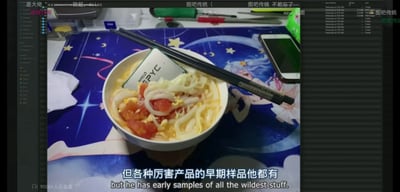 这是一张视频/直播截图，画面中心是一碗西红柿鸡蛋面，碗里直接放入了一块AMD的EPYC服务器CPU，黑色筷子搭在碗沿，面碗放置在印有二次元少女、星月元素的蓝色桌垫上，桌垫旁还摆放着手机、文具等桌面物品。画面顶部有叠加的直播弹幕，底部配有中英双语字幕，是数码硬件爱好者的整活内容，属于玩“CPU压泡面”梗的夸张升级版本。