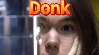 这是一张CS2相关的梗图，主体是CS2职业选手Danil Kryshkovets（ID为Donk）的脸部特写，他一只眼睛睁大看向镜头，另一只眼睛向侧方瞟，手贴在脸颊旁，神情搞怪，画面上方叠加了橙黄色渐变、带有红色粗描边的醒目文字“Donk”，该图常被CS2玩家用来指代枪法激进离谱、正面碾压对手的表现，对应社区“被donk了”的相关梗。