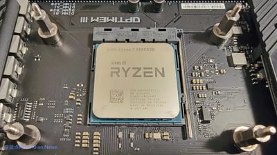 图片展示了一块电脑主板的特写，中央位置安装着AMD Ryzen 7 5800X3D型号的CPU。CPU表面清晰印有'RYZEN'品牌标识、型号信息及生产细节（如'100-000000651'、'MADE IN USA, PACKAGED IN MALAYSIA'、'© 2021 AMD'）。主板上围绕CPU插槽分布着金属固定螺丝、电容及各类电路元件，整体呈现出电脑硬件的精密构造。左下角可见'©蓝点网 Landian.News'的水印标识。