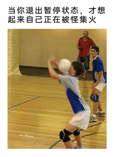 图片上方配有文字'当你退出暂停状态，才想起来自己正在被怪集火'，下方是一张室内排球场景的照片。画面中一名穿着蓝白运动服的男孩正仰头，排球即将砸到他脸上，后方还有另一名男孩和一位穿红色上衣的男子注视着。通过游戏中暂停后忘记危险的场景与现实中即将被球击中的狼狈画面结合，形成幽默的对比，调侃玩家在游戏中的常见窘境。
