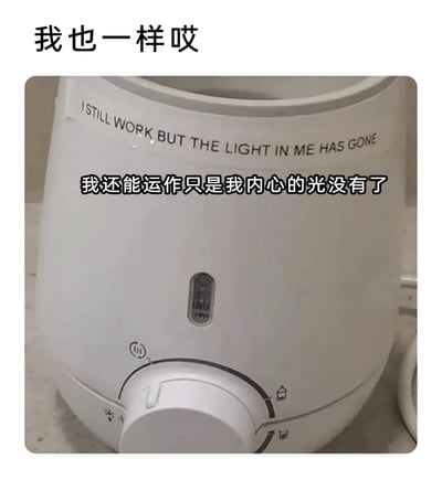 这张静态P图展示了一台白色的厨房小家电，其指示灯处于熄灭状态。图片通过给电器添加拟人化的文字传递情绪：顶部配有文字“我也一样哎”，电器上部有英文文字“I STILL WORK BUT THE LIGHT IN ME HAS GONE”，中部对应中文翻译“我还能运作只是我内心的光没有了”。该图以电器的状态类比当代打工人的职场倦怠——虽然仍在完成工作任务，但已经失去了最初的热情和内心的动力，精准戳中职场人的疲惫心态，极易引发广大打工人的共鸣。