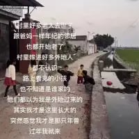 这是一张乡村道路的实拍照片，道路两侧是农田与乡村房屋，画面左侧叠加了一段抒发乡愁的文字：
村里好多客人来了
跟网红一样热闹的街道
也都开始活了
村里迎来好多外地人
都不认识
路上看见的小孩
也不知道是谁的家的
他们都以为我是外地过来的
其实我才是在这里长大的
突然感觉我才是那只鲁
过车我就来
文字讲述了作者回到从小长大的故乡，如今故乡变得热闹如网红村镇，满是外地人，而自己却被当成异乡人，产生了自己才是过客的唏嘘感，字里行间满是物是人非的感慨。