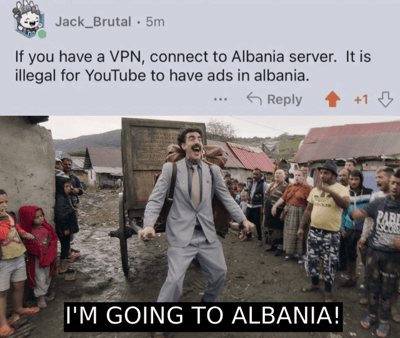 图片上半部分是用户Jack_Brutal的社交媒体评论，内容为“If you have a VPN, connect to Albania server. It is illegal for YouTube to have ads in albania.”（如果你有VPN，连接阿尔巴尼亚服务器，YouTube在阿尔巴尼亚投放广告是非法的）。下半部分是一张真人照片：一名穿着灰色西装、系着领带的男子，背负着一个大型木箱，站在一个有泥土路、低矮房屋和围观村民的村庄场景中，表情兴奋地张开双臂，下方配有文字“I'M GOING TO ALBANIA!”（我要去阿尔巴尼亚了！），整体以幽默方式表达对“阿尔巴尼亚无YouTube广告”这一说法的夸张反应。