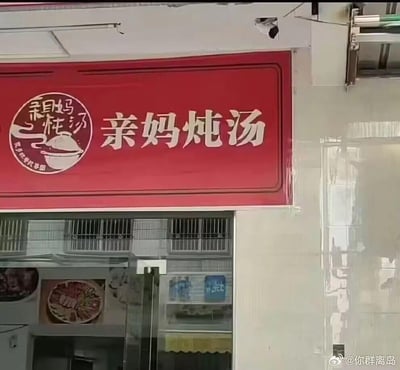 这是一张线下餐饮门店的实拍图，展示了名为“亲妈炖汤”的店铺招牌。招牌为红色底色，搭配白色的“亲妈炖汤”大字，左侧还有圆形艺术字logo，内有“亲妈炖汤”字样和汤碗图案，下方小字写着“为您把爱炖进汤里”，传递出家常、暖心的氛围。招牌下方是店铺的玻璃门，门内可以看到张贴的菜品展示图，能感受到这是一家主打炖汤的家常餐饮店，用“亲妈”作为店名，主打像家人炖煮的汤品的亲切感，没有双关或谐音梗。