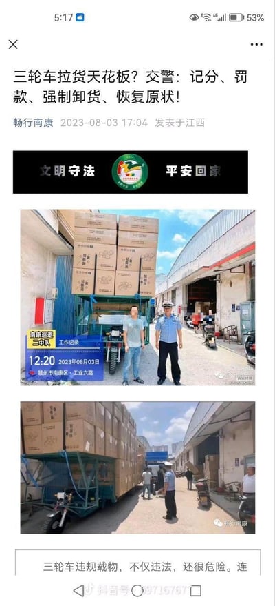 这是一篇由赣州市南康区交警相关官方账号发布的交通违法执法记录文章，展示了一辆三轮车严重违规超高载货的场景：第一张图中，一辆蓝色三轮车的货厢上堆叠了多层货物箱，高度远超车辆本身，执勤交警与面部打码的涉事车主站在车旁，画面左下角的工作记录牌标注了执法时间为2023年8月3日12:20，地点是赣州市南康区工业六路，执法单位为南康巡逻二中队；第二张图则展示了交警在现场监督，对违规货物进行强制卸货的场景。文章通过这组实拍图，明确此类违规行为的处罚措施为记分、罚款、强制卸货并恢复车辆原状，同时警示大众三轮车违规载物不仅违反交通法规，还存在极大的安全隐患。