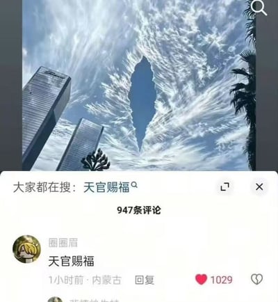 这张图上半部分是仰拍的城市景观，画面中可见两栋现代摩天大楼、棕榈树，天空的云层形成了特殊的狭长空白形态，视觉效果和热门网文IP《天官赐福》的相关经典意象高度相似；图的下半部分是该内容对应的社交平台界面截图，显示关联搜索词为“天官赐福”，共有947条评论，热门评论内容为“天官赐福”，获得了1029个点赞，体现出网友普遍将该特殊云景和《天官赐福》IP关联玩梗的情况。