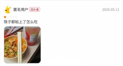 这是一张外卖平台的用户评价截图，右上角标注评价发布时间为2026年5月11日，评价发布者为带有「回头客」标识的匿名用户，该用户仅给商家打出1星评分，评价配文为「筷子都粘上了怎么吃」，下方附带的实拍图中显示一份装有菜肴的外卖餐盒旁放着一双还未掰开的连体一次性筷子，发布者误将需要自行掰开的全新连体一次性筷子当成是粘在一起无法使用的问题商品，因此给出差评，内容极具喜剧效果。