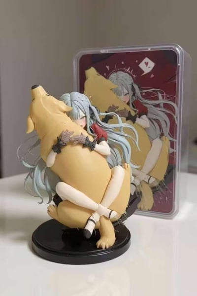 图中展示了一款二次元同人手办，主体是一位银长发的少女，身着红色短上衣，戴着带波点的黑色手套，双手亲昵地抱着一只大型黄色狗狗，双腿交叉盘坐在狗狗身上，姿态十分亲昵。手办后方放置着印有该手办对应原画的透明收纳盒，原画里少女与狗狗的互动姿态和手办高度一致，整体氛围温馨治愈。手办细节还原度较高，发丝的纹理、手套的装饰、狗狗的毛发质感都有细致体现，是二次元爱好者的收藏类手办。