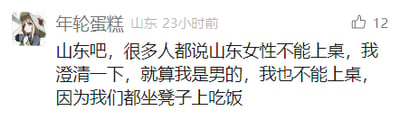 这是一张来自百度贴吧的社交媒体截图，IP属地为山东的用户“年轮蛋糕”发布了一条针对地域刻板印象的搞笑澄清发言。针对网络上流传的“山东女性不能上桌吃饭”的说法，该用户以幽默的方式回应，称自己作为男性也不能上桌吃饭，原因是当地吃饭都是坐凳子，这里的“上桌”其实是外界对山东传统用餐场景的误解，用这种接地气的调侃消解了刻板印象里的偏见。该发言获得了12个点赞，发布时间为截图前23小时，截图左上角配有用户的卡通头像，整体界面是典型的贴吧帖子样式。