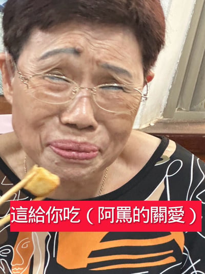 图片中展示了一位长辈正在用筷子喂饭，配文“這給你吃（阿嬤的關愛）”，突出了长辈关爱后辈、用行动表达爱的场景。此类图片常用于表达家人、特别是阿嬤（奶奶）细致入微照顾家庭成员的温馨情感，带有轻松和感动并存的氛围。

没有明显的双关或谐音梗，但“阿嬤的关爱”本身就是一种网络化的情感表达，常常用于调侃或表达亲情中的宠溺、关怀。