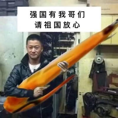 这是一张经过图像编辑软件合成的网络搞笑梗图，图中演员吴京的双手被P上了一枚大型橙色导弹，呈现出扛着导弹的姿态，他面带微笑，背景是类似车间的室内环境。图片上方配有文字“强国有我哥们 请祖国放心”，改编自“强国有我，请祖国放心”的正式励志口号，用接地气的“哥们”一词制造反差感，结合吴京在军事题材影视剧中塑造的硬汉形象，以幽默调侃的方式传递出一种带有归属感的责任感，图中没有双关、谐音梗等内容。