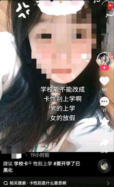 这是一张社交媒体截图，画面主体为一位长发女性（面部经像素化处理），头顶有卡通装饰贴纸。图片中央叠加文字“学校能不能改成卡性别上学啊 男的上学 女的放假”，表达对开学的调侃情绪。下方配文“建议 学校卡♀️性别上学 #要开学了已黑化”，并带有相关话题标签。界面显示167个点赞、21条评论，发布于19小时前，整体呈现出学生对开学的无奈与幽默吐槽场景。