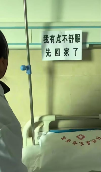 医院病房场景中，一张病床上空无一人，墙上贴着一张手写纸条写着“我有点不舒服 先回家了”。旁边站着一位穿着白色工作服的医护人员，正看着这张空病床和纸条，形成一种幽默的反差感。病人没有办理正规出院手续，而是留下简单字条就自行离开，展现了一种令人哭笑不得的场景。