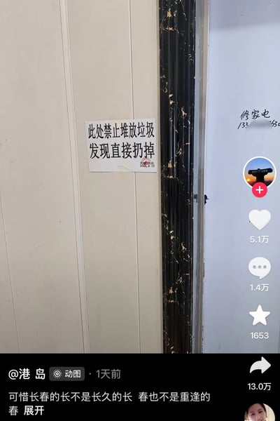 这是一张竖屏的短视频平台界面截图，画面主体是贴在浅色墙面上的物业告示，告示写有“此处禁止堆放垃圾 发现直接扔掉”，右下角盖有天麓物业的公章和2020年4月19日的日期，旁边的黑色门框有掉漆痕迹，右侧墙面还有修家电的小广告。截图右侧是平台的互动按钮，显示该内容获得5.1万点赞、1.4万评论、1653收藏、13.0万转发，底部为发布者@港岛的配文，标注发布于1天前。该告示的趣味点在于表述存在歧义，省略了宾语，容易被误解为发现堆放垃圾的人就直接扔掉，实际本意是发现此处堆放的垃圾就直接扔掉，表述不严谨产生了搞笑效果。