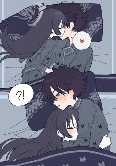 An anime-style illustration divided into two panels. The top panel depicts a couple in bed: a long-haired character and a short-haired character embracing closely, with a small heart symbol near their faces, conveying affection. The bottom panel shows the short-haired character with a surprised expression (indicated by a '?!' speech bubble) while the long-haired character hugs them tightly; both characters have blushing cheeks, enhancing the romantic and cute atmosphere. Both are wearing matching dark pajamas adorned with butterfly patterns, and the background features a bed with patterned pillows.