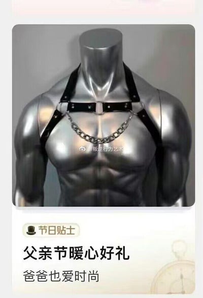 这是一张搞笑的父亲节主题梗图，画面上半部分是银色的人体模型，佩戴着一款黑色皮质搭配金属链条的束缚风格胸带；下半部分是“节日贴士”样式的文案，内容为“父亲节暖心好礼 爸爸也爱时尚”。图的核心笑点在于将偏向小众、个性的特殊风格配饰，包装成适合父亲的时尚礼物，用与大众认知严重不符的“父亲节礼物”设定制造强烈反差，从而产生幽默效果，调侃那些不走寻常路的节日礼物创意。