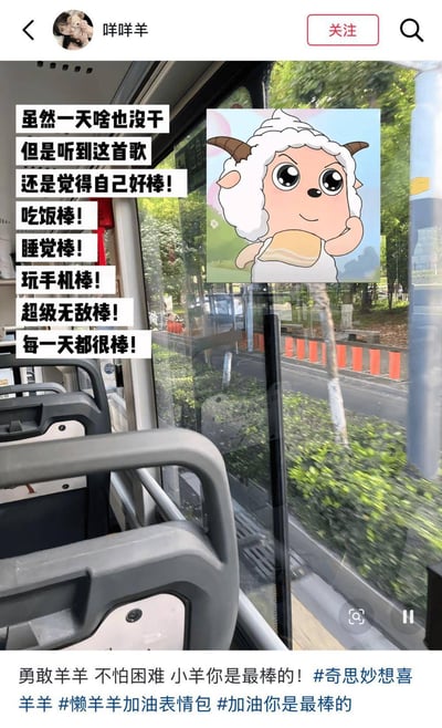 这是一张小红书平台的笔记截图，整体背景是公交车内部的实拍画面，能看到车内的扶手、座椅，车窗外是行驶路过的街道、绿植与道路设施。图片左侧叠加了竖排的黑色粗字配文，内容为调侃式的自我肯定，右侧配有国漫《喜羊羊与灰太狼》中的角色懒羊羊的卡通插画，懒羊羊神态轻松自信，整体氛围活泼治愈。笔记顶部显示发布者昵称为“咩咩羊”，底部配有发布者的配文和相关话题标签。