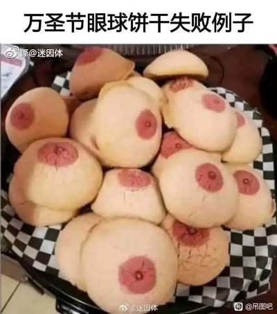 这是一张展示万圣节主题烘焙翻车的实拍图，图中原本计划制作的是万圣节风格的眼球饼干，但成品的形态与预期完全不符：浅色调的饼干主体搭配中间的红色装饰部分，视觉效果酷似人体乳头，和恐怖的眼球造型相差甚远，呈现出滑稽又尴尬的搞笑反差感。这些失败的饼干被堆放在铺有黑白格纹衬纸的容器中，部分饼干表面还有开裂的情况，进一步凸显了烘焙的失败。
