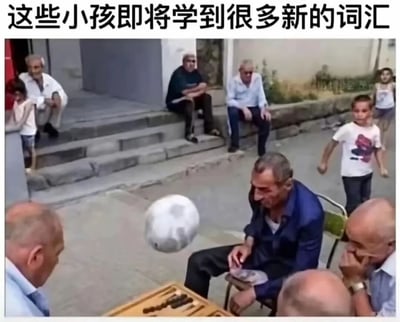 图片顶部有一行醒目的黑色粗体中文：“这些小孩即将学到很多新的词汇”。画面主体捕捉了一个意外发生前的临界瞬间：在一处街边的台阶旁，几位老年男性正围坐在一起玩棋盘游戏（看起来像是西洋双陆棋）。画面中间偏右，一位穿深蓝色衬衫的老人坐在折叠椅上，低头看着棋盘，完全没有注意到一个灰白色的足球正带着运动模糊从画面左侧飞来，即将砸中他。在他身后的街道上，几名儿童正在踢足球。图片的笑点在于对后续情节的预判：足球击中老人后，老人大概率会因突发的疼痛和恼怒而口出脏话或大声咒骂，配文所说的“新词汇”正是暗指这些粗俗的俚语。在一旁踢球的小孩们即将“耳濡目染”学到这些新词，这种预期中的反差和尴尬感构成了强烈的喜剧效果。