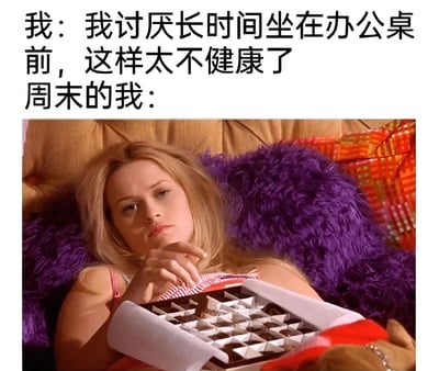 这是一张幽默自嘲类梗图，上方文字写着"我：我讨厌长时间坐在办公桌前，这样太不健康了 周末的我："，下方是电影《律政俏佳人》中女主角艾丽·伍兹慵懒地躺在沙发上，手拿着一盒巧克力的截图。图片通过对比工作日对久坐的抗拒和周末主动躺平吃零食的矛盾行为，展现了现代人的生活状态反差，带有自嘲和幽默的意味。