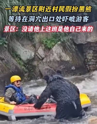 这是一张实拍的图文结合图片，背景为漂流景区的岩石河道，河道旁长有绿植。画面中一名身着黑熊玩偶服的人站在浅水区，伸手朝向刚驶出洞穴的漂流皮艇，皮艇上的游客佩戴黄色头盔、穿着蓝色救生衣，面露惊恐神色。图片顶部叠加了三段说明文字，依次为黄字“一漂流景区附近村民假扮黑熊”、蓝字“等待在洞穴出口处吓唬游客”、红字“景区：没请他上这班是他自己来的”，清晰说明了事件的经过和景区的回应。