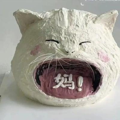 这是一张基于“猫叫妈”网络玩梗的创意图片，整个形象是一只张大嘴、露出夸张表情的猫头手工雕塑或蛋糕，猫张开嘴巴，嘴里突出地写着“妈！”。这类图片以幽默、夸张的方式表达惊讶或崩溃的情绪，经常被网友用来吐槽生活中的无语瞬间或“呼唤妈妈”式求助。没有明显双关和谐音，不过‘妈’字出现在猫嘴里，本身就是流行梗文化的直白呈现。