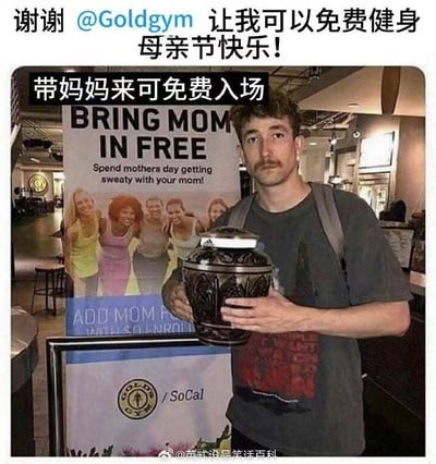 图片中一名男子在健身房内，双手捧着一个黑色花纹骨灰坛，身后是Goldgym健身房的母亲节活动宣传牌，上面写着“BRING MOM IN FREE”及中文“带妈妈来可免费入场”。图片顶部配有文字“谢谢 @Goldgym 让我可以免费健身 母亲节快乐！”。该图通过将“带妈妈”字面理解为携带母亲骨灰坛，制造出荒诞的黑色幽默效果，调侃健身房的母亲节促销活动。