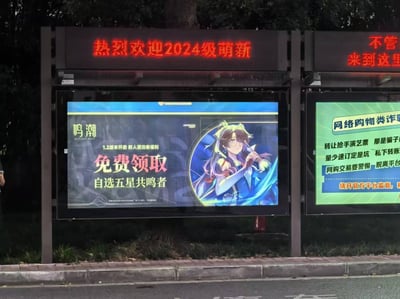 这是一张实拍的户外公交站场景照片，上方电子滚动屏显示红色的「热烈欢迎2024级萌新」标语，下方左侧是二次元动作游戏《鸣潮》的1.2版本推广广告，主打「免费领取自选五星共鸣者」的新人玩家福利，右侧则是网络购物类诈骗的反诈宣传海报。三种不同主题的内容同框呈现，营造出一种次元壁与现实场景交融的趣味感。
无双关、谐音梗或暗示类内容。