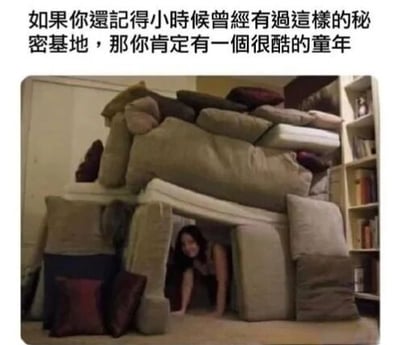 图片上方配有文字“如果你還記得小時候曾經有過這樣的秘密基地，那你肯定有一個很酷的童年”，下方是一张实景照片：一个人正从由多个枕头、靠垫堆叠搭建的“堡垒”中探出头来，背景可见书架和室内环境。整体画面充满怀旧感，通过生活化的场景唤起人们对童年用日常物品创造秘密空间的温馨回忆。