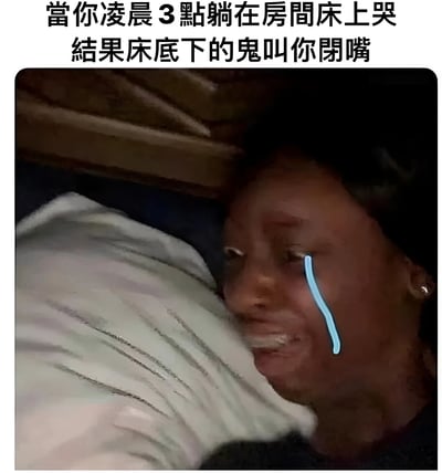 图片上方配有文字“當你凌晨3點躺在房間床上哭 結果床底下的鬼叫你閉嘴”，下方是一张真人躺在床上的照片，人物脸上被添加了一道蓝色的眼泪特效，表情看起来既惊恐又有些无奈。整个画面通过反转常见的“床底有鬼”恐怖场景，营造出一种黑色幽默的搞笑效果，原本应该吓人的鬼魂反而因为被哭声打扰而让主角闭嘴，形成了强烈的反差萌。