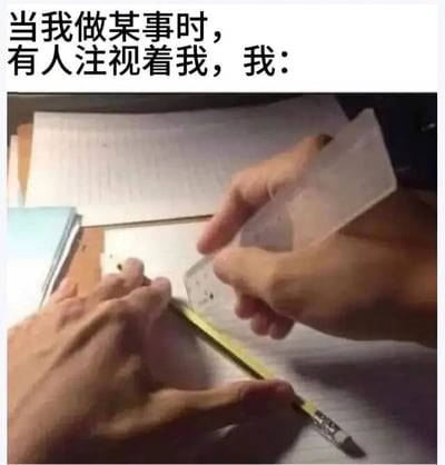 图片上方配有文字'当我做某事时，有人注视着我，我：'，下方是一张实拍图，展示两只手正拿着尺子和铅笔，似乎在试图画直线，但手部动作显得有些僵硬和不协调，生动表现了人们在被他人注视时做事容易变得紧张、不自然的尴尬状态。