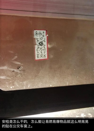 这是一张在公交车内拍摄的照片，车窗玻璃上贴着一张红边的类似传统符箓的贴纸，贴纸中间有显眼的书法字体“爆”字，其余为草书字体难以辨认。图片下方配有吐槽文字：“安检是怎么干的，怎么能让易燃易爆物品就这么明晃晃的贴在公交车窗上。”拍摄者误以为这个带“爆”字的贴纸是易燃易爆相关物品，从而吐槽安检疏漏，实际上是一场乌龙误会，贴纸只是装饰类的符箓样式贴画。