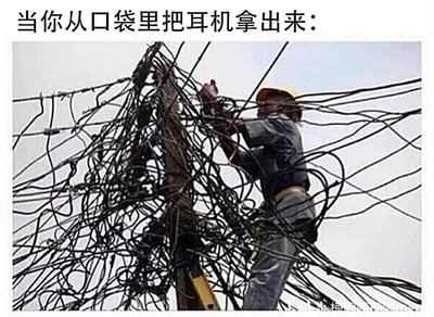 这是一张用来吐槽日常小烦恼的搞笑梗图，图片顶部配有文字“当你从口袋里把耳机拿出来：”，下方主体是一张真实的户外作业照片：一名头戴黄色安全帽、身穿灰色工作服的线缆维修工人，正站在电线杆上，试图梳理缠绕在一起、如同乱麻般的大量黑色电线，这些电线极度杂乱，交织缠绕成密集的一团，工人置身其中，看起来十分棘手。这张图用夸张的类比手法，将从口袋中取出后缠结的耳机线，比作这团理不清的电线，生动又幽默地放大了人们面对缠结耳机线时那种无从下手、崩溃无奈的心情，引发大众对日常这一小困扰的共鸣。