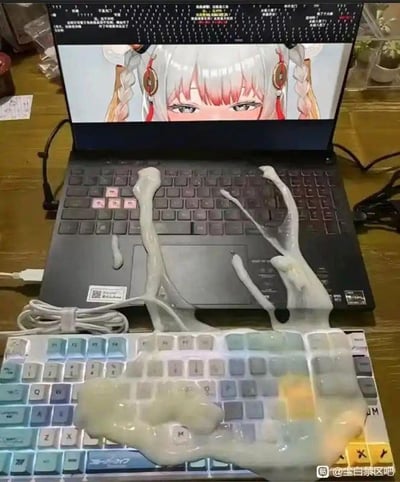 这张图片展示了一个充满恶搞意味的场景：一台打开的笔记本电脑屏幕上显示着一位银发带粉色挑染、佩戴红色耳饰的二次元女性角色，屏幕上方还有一段无法辨认的代码内容。笔记本键盘和下方的外接键盘上都沾满了类似清洁软胶的半透明粘稠物体，软胶从外接键盘延伸到笔记本键盘上，形态扭曲，营造出一种猎奇又搞笑的视觉效果。整个画面看起来像是故意布置的恶搞场景，调侃了沉迷二次元的玩家的夸张行为，或是玩了键盘清洁的反向梗，没有双关、谐音等额外暗示。