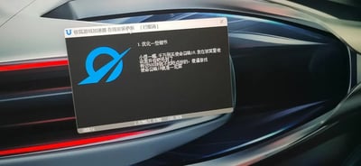 图片展示了极狐游戏加速器的在线安装更新窗口，状态显示为[已取消]。窗口顶部有软件名称“极狐游戏加速器”及更新类型标识，中央是蓝色品牌logo，下方列出更新内容“1. 优化一些细节”。窗口内还包含一段用户吐槽文字，内容为小编反馈因“使命召唤19”被误判使用违规设备导致封号，并建议优化账号检测机制。进度条显示更新进度为“1.57MB / 5.7MB 100% 100%”，速度为“01B/s”。背景为模糊的汽车内饰，带有金属质感的流线型设计和红色线条点缀，整体呈现科技感。