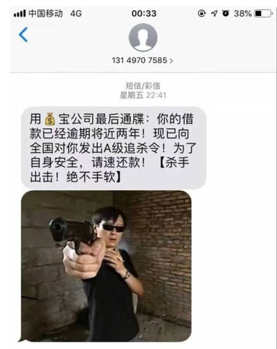 这是一张手机短信界面截图，显示来自未知号码的催收短信。短信内容以'用💰宝公司'名义发出最后通牒，声称借款逾期近两年，已发出'A级追杀令'，并附有一张男子持枪指向镜头的照片，背景为砖墙。整体内容荒诞夸张，明显是用于搞笑讽刺的虚假催收信息，旨在调侃此类诈骗短信的拙劣手法。