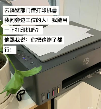 办公室场景中，一台HP打印机放在桌面上，旁边有绿色盆栽。图片上方叠加文字描述了一个职场趣事：去隔壁部门借打印机时，询问工位旁的人能否使用，对方幽默回复‘你把这炸了都行！’，通过夸张表达吐槽打印机可能经常出故障、不好用的状况，充满调侃意味。