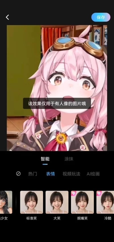 这是一张竖屏的手机工具软件界面截图，展示的是修图类APP的AI表情替换功能页面。页面上方显示一张粉色长发、头戴护目镜的二次元卡通女孩图片，图片中间弹出黑色背景的系统提示框，文字内容为“该效果仅用于有人像的图片哦”，界面右上角有浅蓝色的“保存”按钮。页面下方是功能操作区域，分为“智能”“涂抹”两个模式选项，当前处于“智能”模式；下方的标签栏包含“热门”“表情”“视频玩法”“AI绘画”，当前选中“表情”标签。在“表情”分类下，展示了五款真人表情模板，从左到右依次标注为“少少女”“标准笑”“大笑”“抿嘴笑”“冷酷”，其中后三个模板的右上角带有爱心形状的收藏标识。