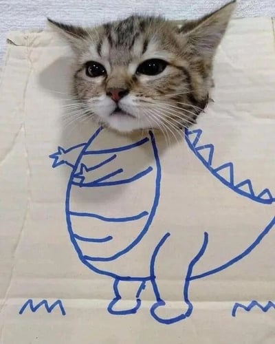 一只虎斑小猫的脑袋从一张纸上的洞口探出，纸上用蓝色马克笔手绘了一个卡通恐龙的身体，小猫的头部恰好成为了恐龙的头部，形成了猫咪“变身”恐龙的可爱创意效果。小猫有着圆圆的大眼睛，眼神好奇又无辜，胡须清晰可见，与手绘的恐龙身体搭配得十分和谐有趣，整体画面充满童真和萌感。
