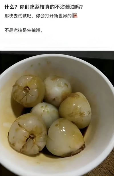 图片上半部分为黑色文字内容：'什么？你们吃荔枝真的不沾酱油吗？那快去试试吧，你会打开新世界的😱 不是老抽是生抽哦。' 下半部分是一张实拍图，展示了一个白色碗中装着几颗浸泡在生抽里的去皮荔枝，荔枝果肉呈半透明状，表面裹着深色的酱油汁。整体通过文字和实物照片结合的方式，推荐一种将荔枝蘸生抽食用的独特吃法，语气中带有惊讶和强烈推荐的意味。