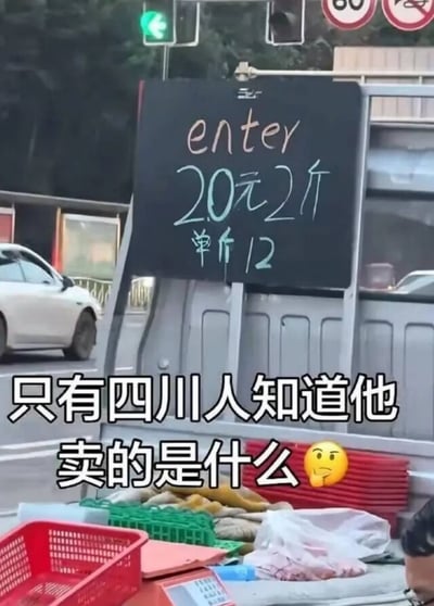 这是一张街头流动摊位的实拍图，画面主体是小货车上挂的黑色价格告示牌，上面写有英文“enter”，下方标注价格“20元2斤，单斤12”，图片下方加注了白色文字“只有四川人知道他卖的是什么”，搭配一个托腮思考的表情。此处玩了方言谐音梗：英文enter的发音和四川方言里对樱桃的称呼“恩特儿”发音高度近似，所以摊主实际售卖的是樱桃，只有熟悉四川方言的人才能快速看懂招牌含义。背景可见道路、亮着绿灯的交通信号灯、行驶的私家车、限速和禁止鸣笛的交通标识，摊位上还摆放有塑料筐、货品、杂物等，右下角露出了摊主的部分头部。