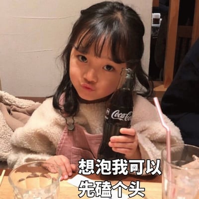图片中是韩国女童星权律二，她留着黑色长发，齐刘海，穿着白色毛绒外套和粉色背带裤，正坐在餐桌前，右手拿着一瓶可口可乐。桌上放着透明玻璃杯，里面有冰块和吸管。图片底部有文字“想泡我可以 先磕个头”，结合她俏皮的表情，营造出可爱又带点小傲娇的氛围。