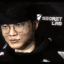 这是一段《英雄联盟》传奇职业选手Faker（李相赫）的动态GIF图，图中他戴着黑框眼镜与黑色帽子，嘴唇做出抿动、微张的动作，神态显得微妙又带点嫌弃感，常被电竞圈网友用作表达无语、嫌弃等复杂情绪的表情包。