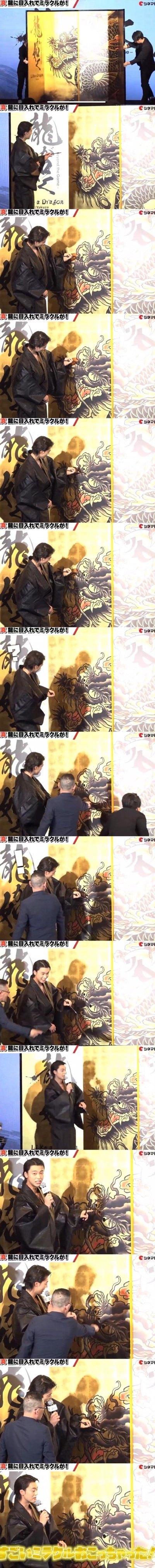 这是一组来自日本游戏《如龙》（Yakuza）相关线下宣传活动的直播画面截图，以连环图的形式完整记录了“画龙点睛”的仪式过程：画面起始是工作人员揭开龙画的遮挡，随后一位身着黑色传统风格服饰的男性手持画笔，逐步为这幅充满日式浮世绘风格的龙画的眼睛上色、调整细节，期间有工作人员上前提供协助，最终完成点睛并展示成品。图中顶部的日文标语“真、龍に目入れでミラクルが！”意为“真·给龙点睛就会有奇迹！”，画旁的英文“beyond the Game- a Dragon Yakuza”也明确了活动与《如龙》系列的关联，整体仪式感十足，借中式传统画龙点睛的寓意为作品造势。