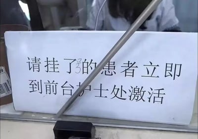 这是一张在医院窗口拍摄的提示牌照片，白色背景的提示牌上用黑色字体写着挂号患者的指引信息：“请挂了号的患者立即到前台护士处激活”，其中“号”字是手写添加在“了”字后方，用于补全原本遗漏的文字。提示牌后方能看到医院医护人员的身影，整体场景是医院的服务窗口区域，用于指引刚完成挂号的患者进行下一步激活操作，内容正式清晰，具有明确的指引性。