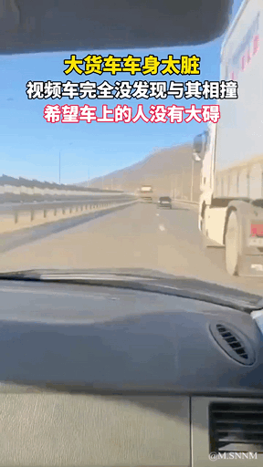 这是一段行车记录仪的竖屏视频截图，画面呈现高速公路场景，右侧的大货车因车身极度脏污，颜色与路面背景近乎融为一体，导致拍摄视频的车辆完全没有发现它，正处于即将相撞的危险状态。图中叠加了黄色和白色的字幕文字：“大货车车身太脏 视频车完全没发现与其相撞 希望车上的人没有大碍”，点明了事故诱因，并表达了对涉事人员安全的关切。