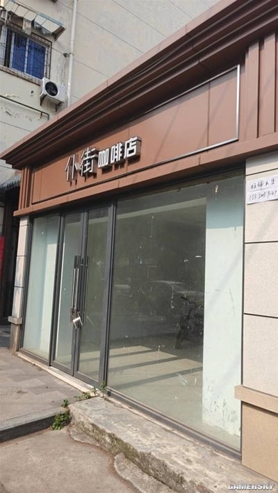 一张展示名为"仆街咖啡店"的店铺外观照片。店铺有棕色的招牌和玻璃门，门内看起来是空的。玻璃窗上贴有电话号码"135 8667 9697"。照片右下角有"GAMERSKY"水印。

"仆街"在粤语中是粗话，意思是"摔倒在街上"或诅咒他人，用作咖啡店名称显得非常奇特和幽默。